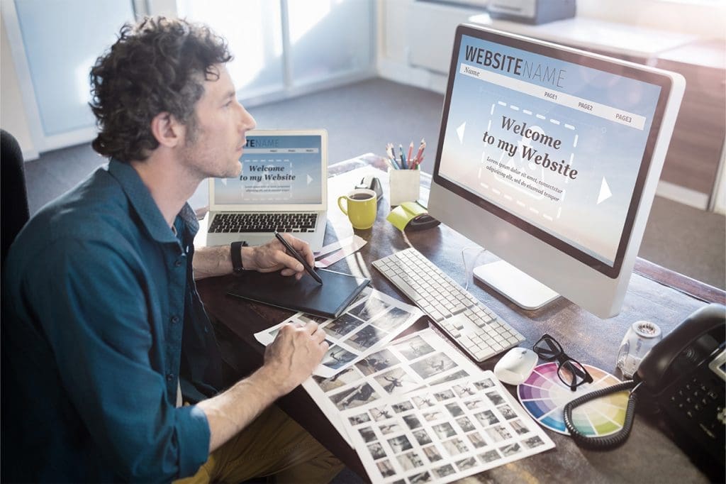 Business owner at his desk thinking about a Website Redesign